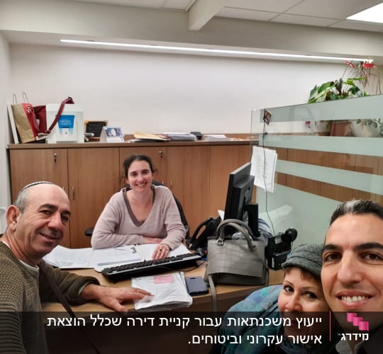 יועצת משכנתאות יושבת ליד מחשב עם לקוחות